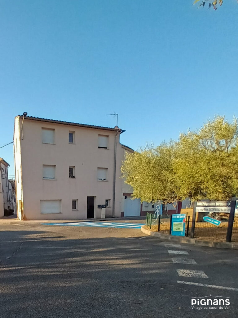 un bâtiment avec des arbres à l’arrière
